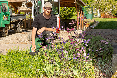 Grünpflegearbeiten machen Elmanuel Breitzke mehr Freude als Pflastern. Elmanuel Breitzke vor einem Beet mit Nutzpflanzen