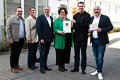 (v.l.): Marc Fischer (Geschäftsf. IFB Rhein-Main), Andrea Hausy (Inklusionsbeauftragte Wiesbaden), OB Gert-Uwe Mende, LWV-Landesdirekt. Susanne Simmler, Sebastian Wille (Abteilungsl. Kinder-Catering), Heiko Kretschmer (Prokur. IFB Job Wiesbaden gGmbH) Gruppenfoto von der Bescheidübergabe