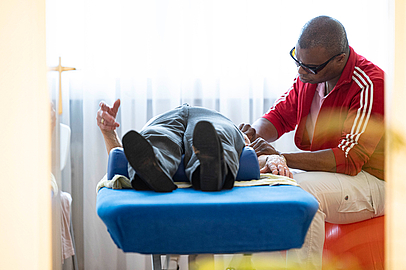Beruf als Berufung: Der sehbehinderte Elliot Young ist ein Gewinn für die Physio-therapiepraxis. (Fotos: Salome Roessler) Elliot Young bei der Behandlung eines Patienten